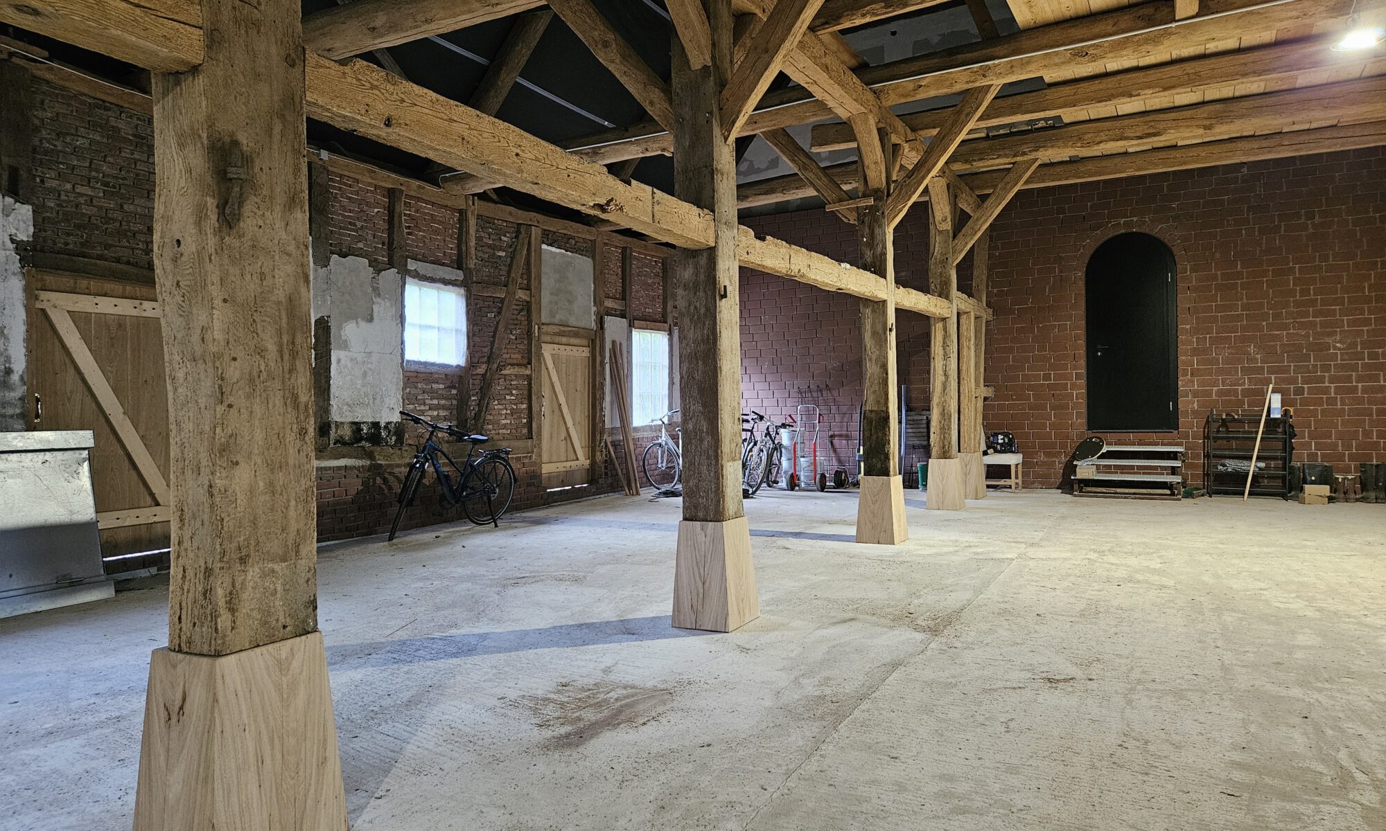 Geräumiger alter Scheuneninnenraum mit Holzbalken und Fahrrädern