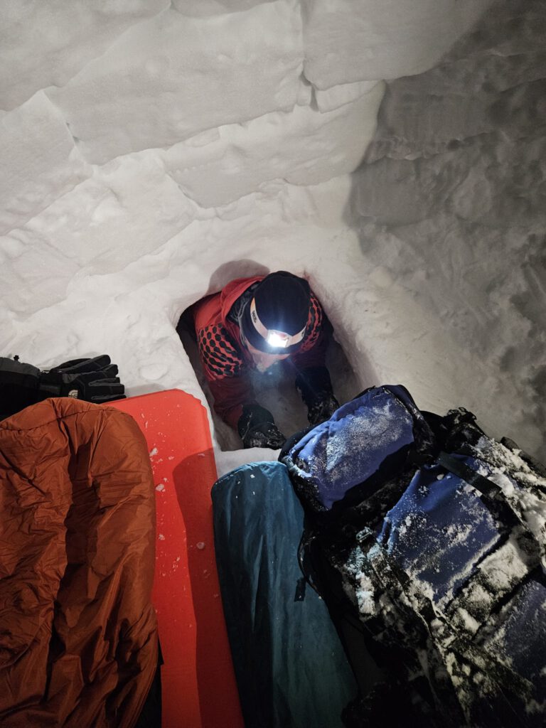 Person in Schneehöhle mit Schlafsäcken, Asventure, Überleben, Nacht