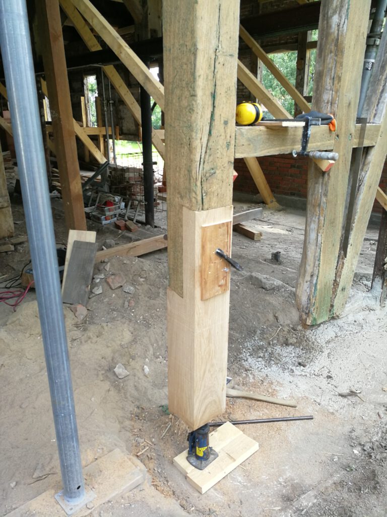 Sanierung und Stabilisierung eines alten Holzbalkens in Baustelle